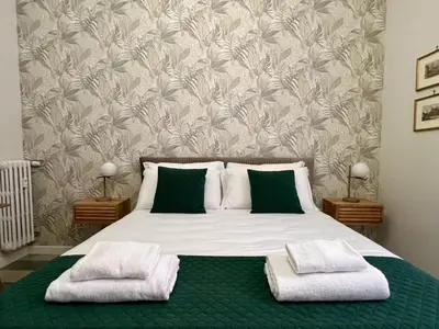 a bedroom with a bed with green and white pillows at Domus Dolce Vita - Apartment in Rome