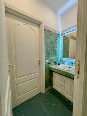 a bathroom with a white door and a sink at Domus Dolce Vita - Apartment in Rome
