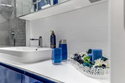 a bathroom with a sink and blue bottles on a counter at White Living R-home in Rome