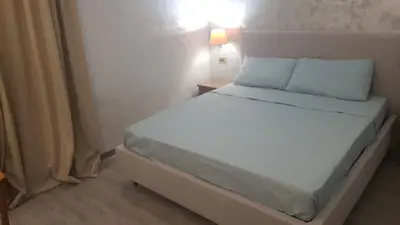 a bedroom with a white bed with a light on it at Sandel Giubileo Hotel in Rome