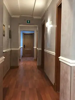 an empty hallway in an office building with wood floors at Sandel Giubileo Hotel in Rome