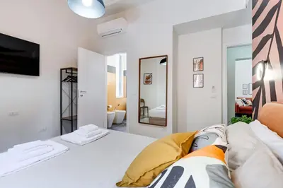 a white bedroom with a bed and a mirror at BDC - Termini Dreaming 3-BDR in Rome