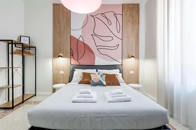 a bedroom with a large bed with a large painting on the wall at BDC - Termini Dreaming 3-BDR in Rome