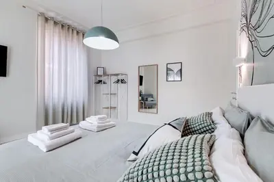 a white bedroom with a bed and a large window at BDC - Termini Dreaming 3-BDR in Rome