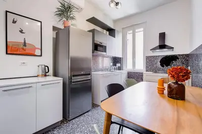 a kitchen with a table and a refrigerator at BDC - Termini Dreaming 3-BDR in Rome