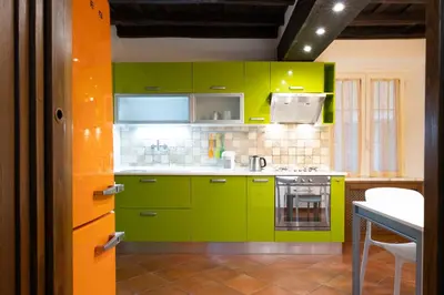a kitchen with lime green cabinets and a table at Domus LXVII Monti in Rome