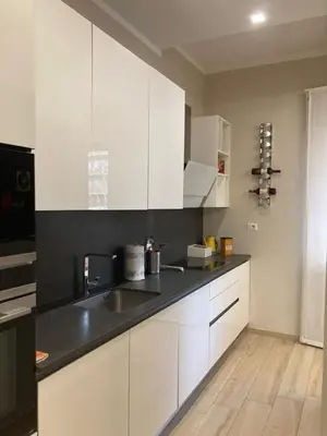 a kitchen with white cabinets and a black counter top at Cami Luxury Flat Rome in Rome