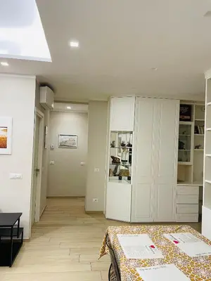 a white room with a bed and a kitchen at Cami Luxury Flat Rome in Rome