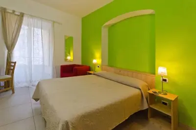 a green bedroom with a bed and a chair at B&B Alle Porte di San Giovanni in Rome