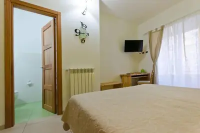 a bedroom with a bed and a clock on the wall at B&B Alle Porte di San Giovanni in Rome