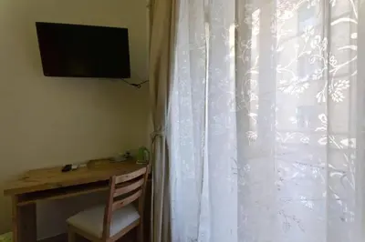 a room with a desk and a window with a white curtain at B&B Alle Porte di San Giovanni in Rome