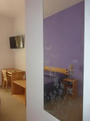 a room with a bedroom with a table and a wall at B&B Alle Porte di San Giovanni in Rome