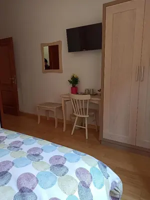 a room with a bed and a table and a mirror at B&B Alle Porte di San Giovanni in Rome