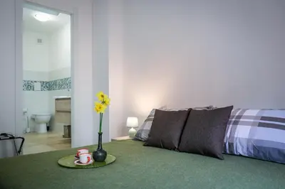 a bedroom with a bed and a table with a vase with flowers at Marconi Suites in Rome