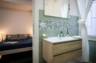 a bathroom with a sink and a bed at Marconi Suites in Rome