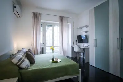a bedroom with a green bed and a window at Marconi Suites in Rome