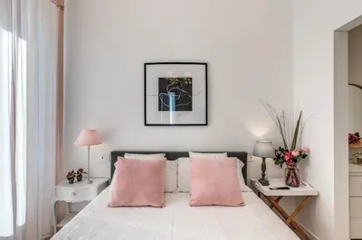a white bedroom with pink pillows on a bed at Fresh House Vaticano in Rome