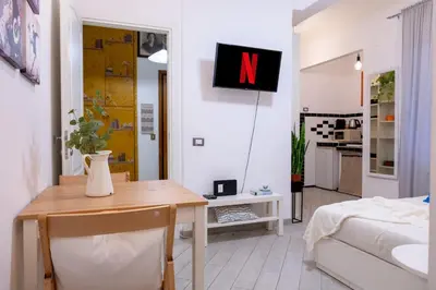 a living room with a table and a tv on the wall at Stanza Comoda e Silenziosa con Bagno Privato e Area Lavoro e Relax in Rome