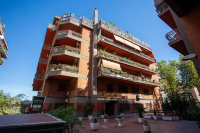 a red building with balconies and plants on it at Stanza Comoda e Silenziosa con Bagno Privato e Area Lavoro e Relax in Rome