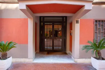 a door of a building with two palm trees in front at Stanza Comoda e Silenziosa con Bagno Privato e Area Lavoro e Relax in Rome