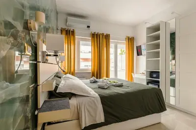a bedroom with a bed and yellow curtains at Perfect! Vatican Location in Rome