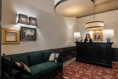 a woman standing in a living room with a green couch at V Collection Condotti in Rome