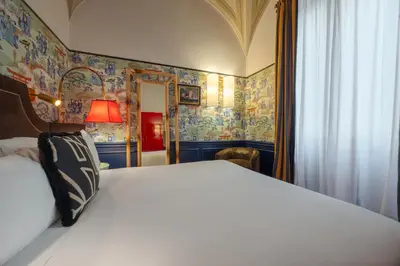 a bedroom with a white bed with colorful wallpaper at V Collection Condotti in Rome