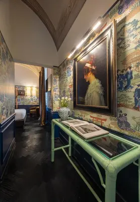 a room with a table with a painting on the wall at V Collection Condotti in Rome