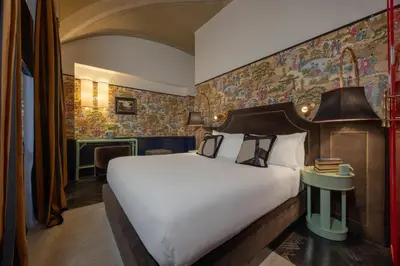 a hotel room with a bed and a wall with a mural at V Collection Condotti in Rome