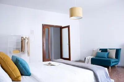 a bedroom with two beds and a blue chair at Tommys flat by DomusDimore in Rome