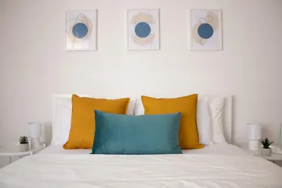 a white bed with yellow and blue pillows on it at Tommys flat by DomusDimore in Rome