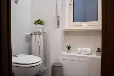 a white bathroom with a toilet and a sink at Tommys flat by DomusDimore in Rome