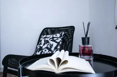 an open book on a table next to a chair at Tommys flat by DomusDimore in Rome