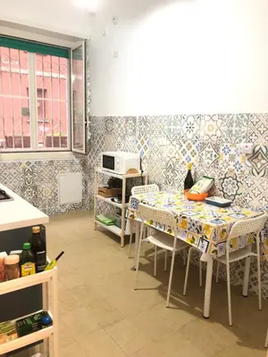 a kitchen with a table with chairs and tiles at LoL Apartment in Rome