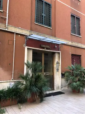 a building with palm trees in front of it at LoL Apartment in Rome