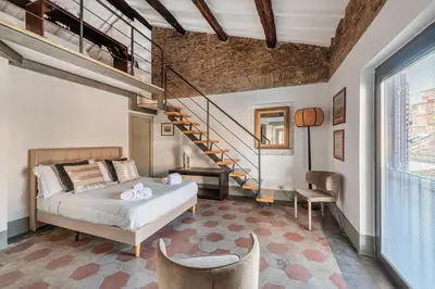a bedroom with a bed and a staircase at Torretta Luxury Attico in Rome