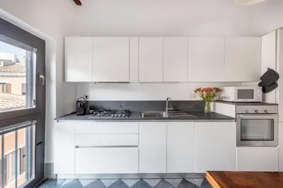 a white kitchen with a sink and a microwave at Torretta Luxury Attico in Rome
