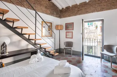 a bedroom with a bed and a spiral staircase at Torretta Luxury Attico in Rome