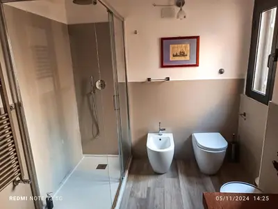 a bathroom with a glass shower and a toilet at Torretta Luxury Attico in Rome