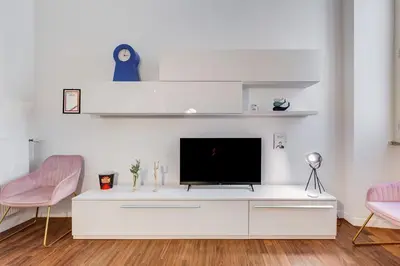 a living room with a tv and two pink chairs at InTheMoodForRome - Musei Vaticani in Rome
