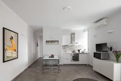 a white apartment with a table and a kitchen at Nice and spacious apartment near the Vatican and Starbucks in Rome