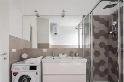 a bathroom with a washing machine and a sink at Nice and spacious apartment near the Vatican and Starbucks in Rome