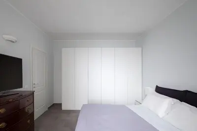 a bedroom with a white bed and a television at Nice and spacious apartment near the Vatican and Starbucks in Rome