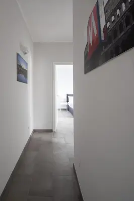 a room with white walls and a hallway with paintings at Nice and spacious apartment near the Vatican and Starbucks in Rome