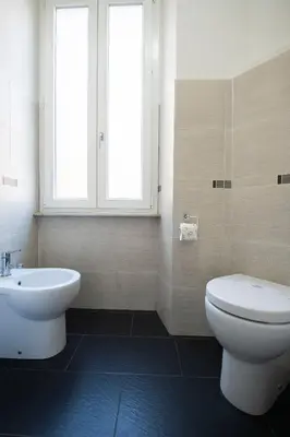 a bathroom with a toilet and a sink and a window at Domus Collazia - San Giovanni Apartment in Rome