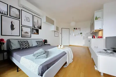 a white bedroom with a bed and a desk at Annasole's flat by Domus&Dimore in Rome