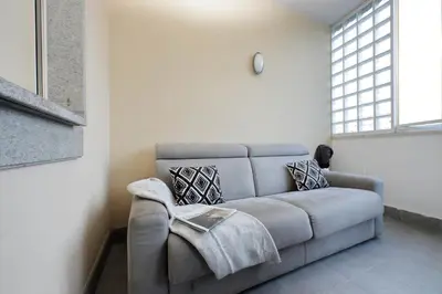 a gray couch in a room with a window at Annasole's flat by Domus&Dimore in Rome