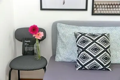 a vase with a pink flower sitting next to a chair at Annasole's flat by Domus&Dimore in Rome