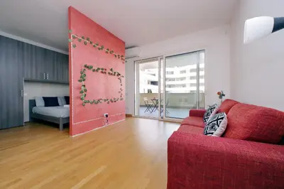 a living room with a red couch and a large window at Claudias flat by DomusDimore in Rome