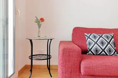 a red couch with a table next to a side table at Claudias flat by DomusDimore in Rome